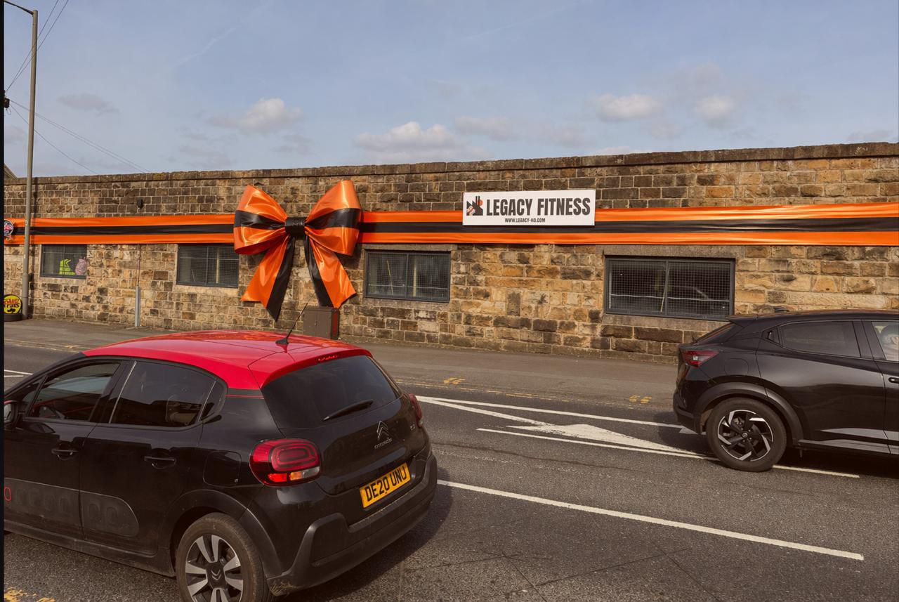 Legacy HQ building front with large orange and black ribbon and bow